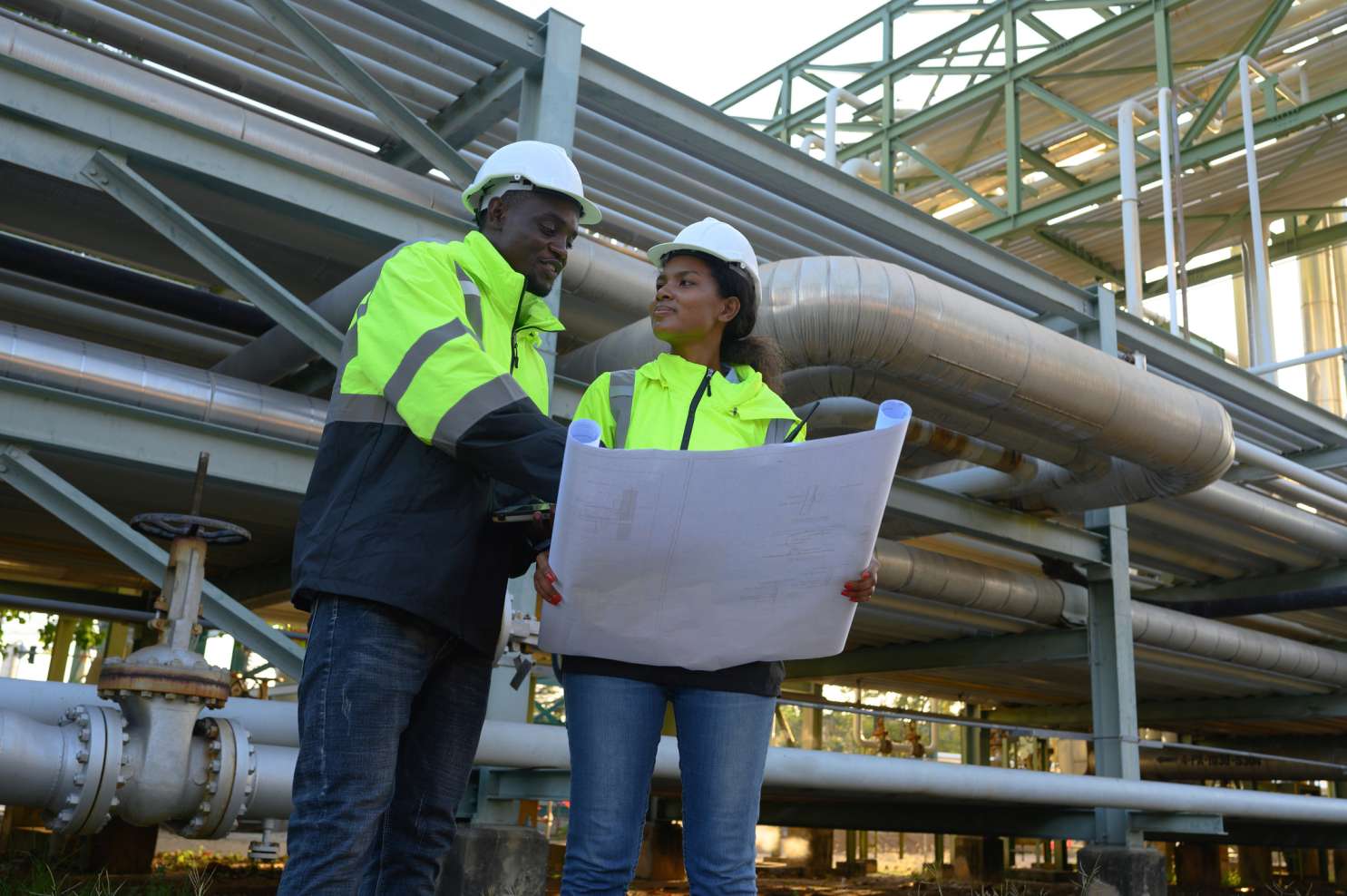 Engineers reviewing blueprint at industrial site
